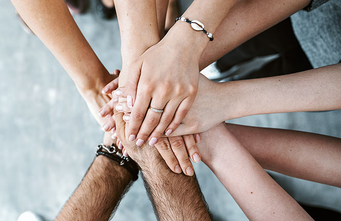 Diverse group of hands in a circle, sitting on top of each other
