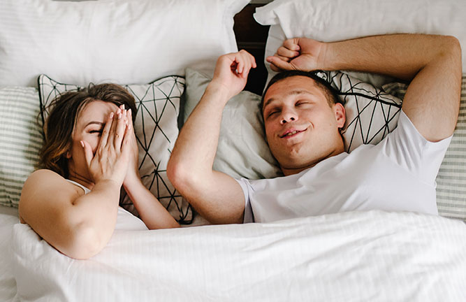 Couple in bed looking satisfied to be together