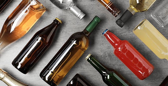 Photo of various alcohol bottles laying on their sides. Beer, liquor and wine