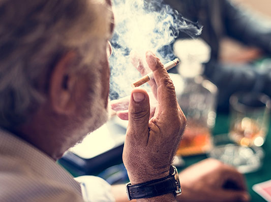 Man smoking while playing cards