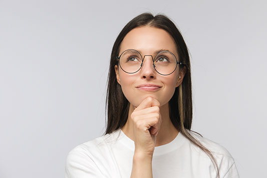 Woman with glasses with a positive hopeful look on her face