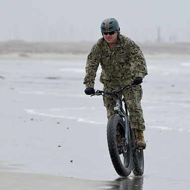Servicemember cycling on the beach