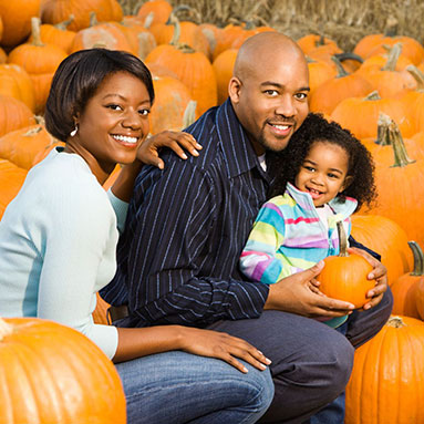 Father, mother and daughter at a pumpkin patch