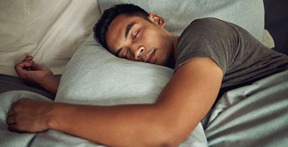 Man sleeping comfortable with his arm over the pillow