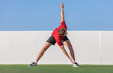 Man doing dynamic stretching while standing