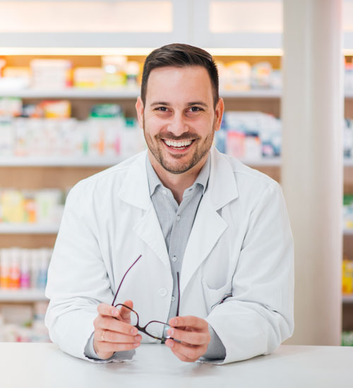 A smiling pharmacist in a pharmacy