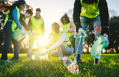 Group of young adults volunteering by picking up litter