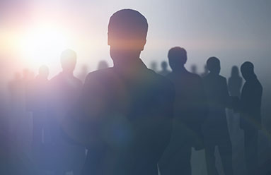 Silhouettes of a crowd of people, showing primarily their heads and shoulders