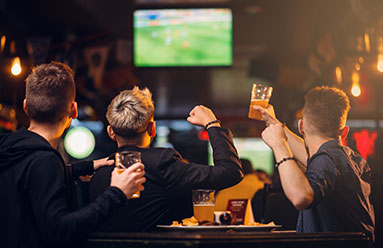 Men at a bar watching a sporting event