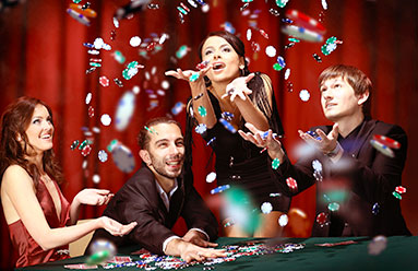 Group of young adults gambling. They have thrown chips in the air in celebration