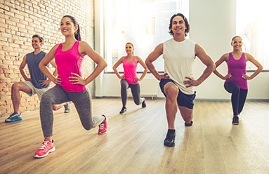 Group of people exercising together, lunging